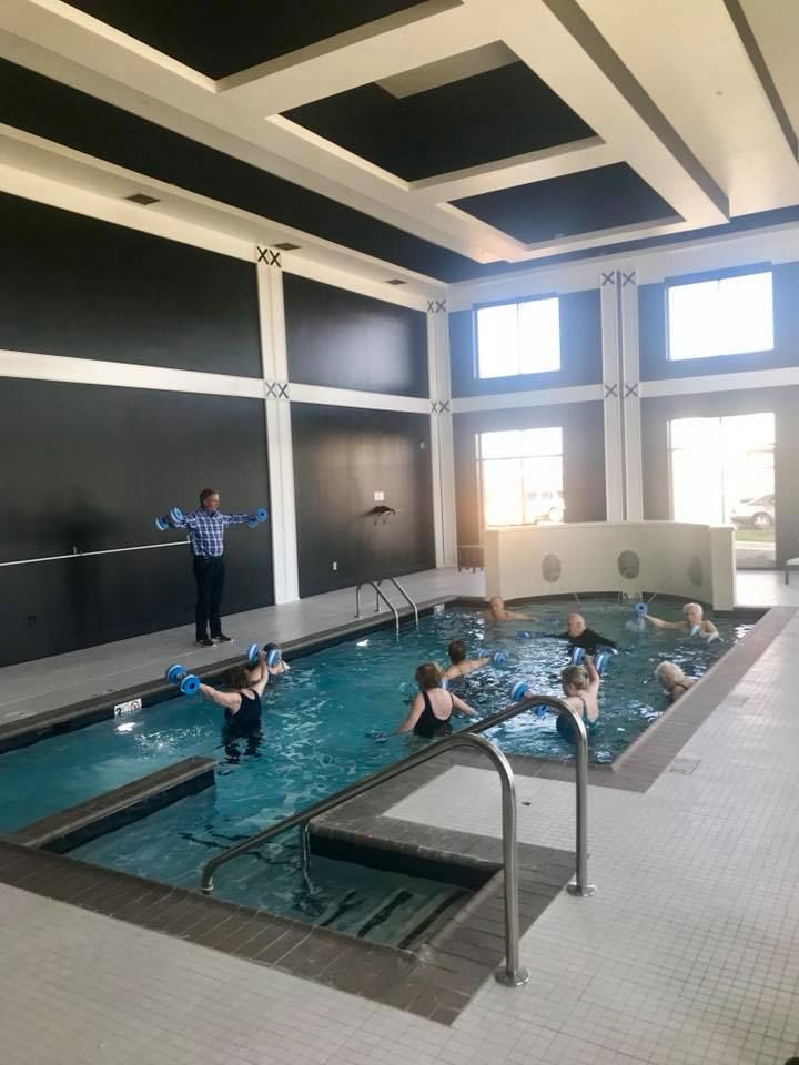 A group of people participating in an indoor aquatic exercise class.