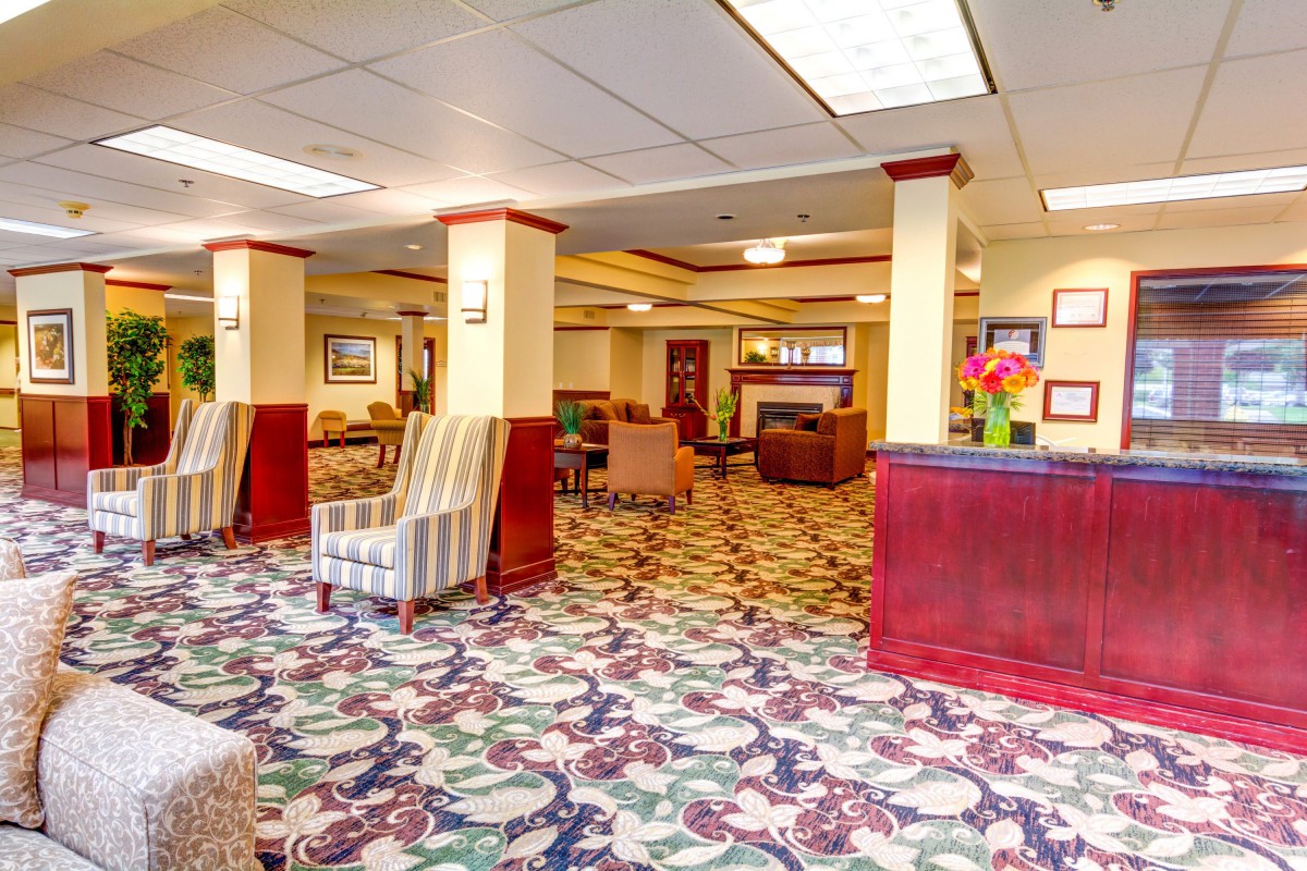 A spacious hotel lobby with patterned carpet and comfortable seating.