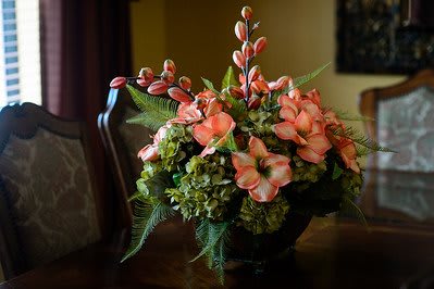 A beautiful floral arrangement with pink flowers and lush green leaves displayed on a table.