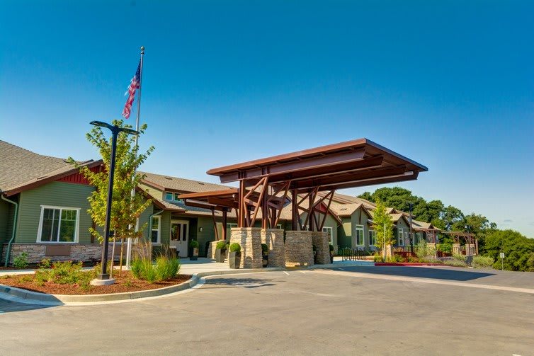 A well-designed building entrance with a large awning and landscaped surroundings.
