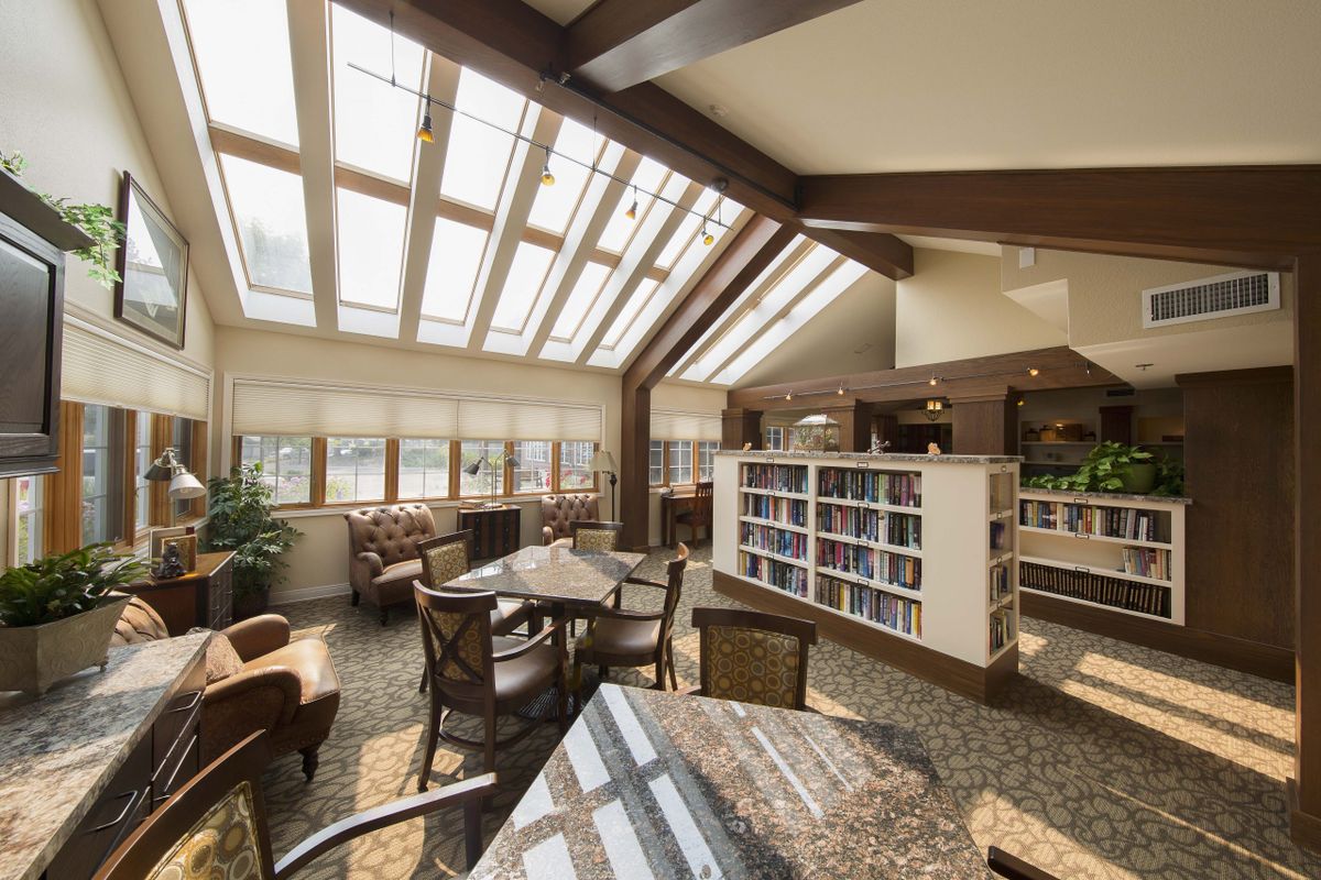 A cozy library interior with skylights providing natural light, featuring bookshelves and comfortable seating.