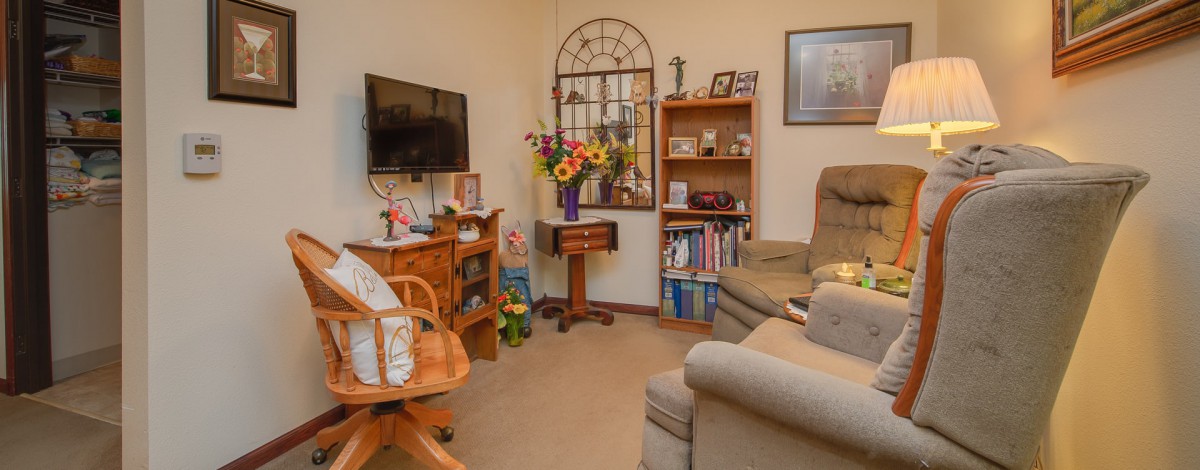 Cozy living room with a bookshelf, TV, and comfortable seating.