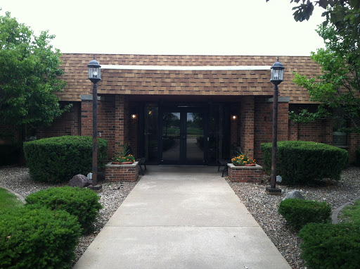 Entrance of a brick building with landscaped surroundings.