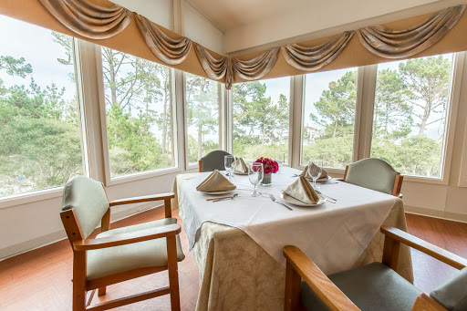 A beautifully set dining table in a cozy restaurant with scenic views.