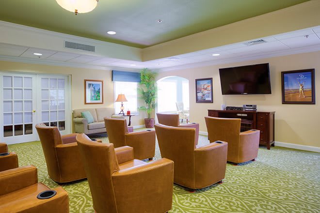A cozy living room with multiple armchairs facing a television.