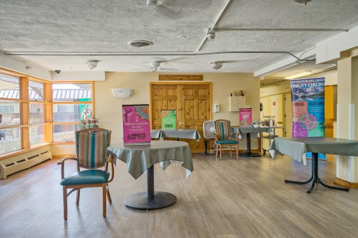A casual dining area featuring tables and chairs, with colorful decorations in the background.