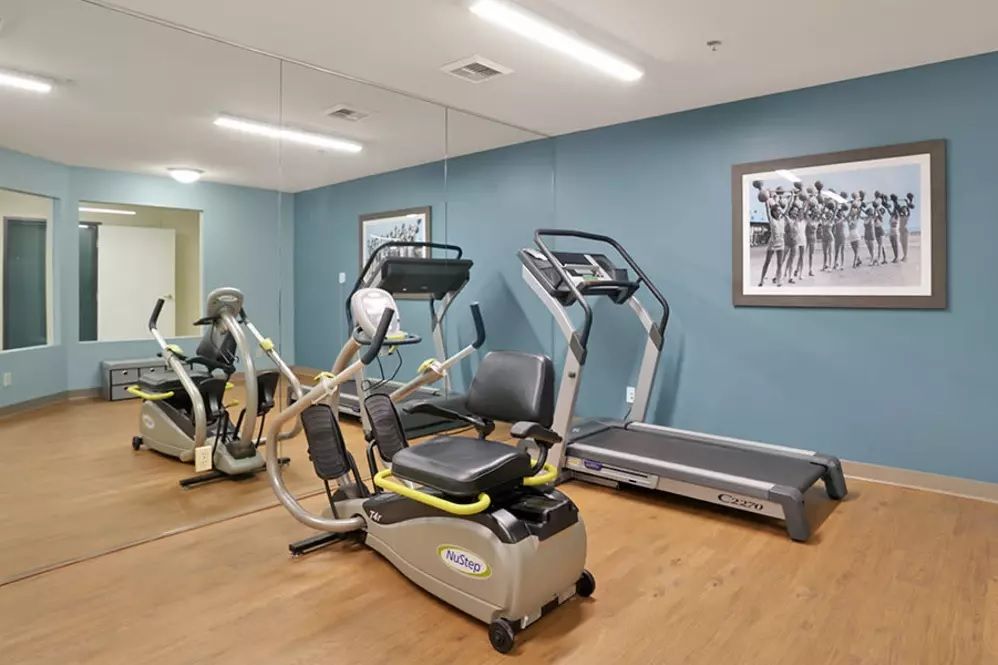 A small gym with exercise equipment, including a treadmill and an exercise bike.
