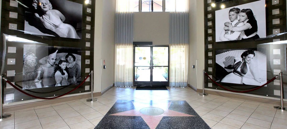A well-lit lobby entrance with glass doors and a star design on the floor.