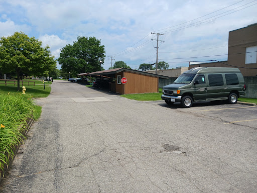 A quiet street scene featuring a parked van and surrounding greenery.