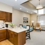 A modern, cozy open-concept kitchen and living area with warm wooden cabinets and stylish decor.