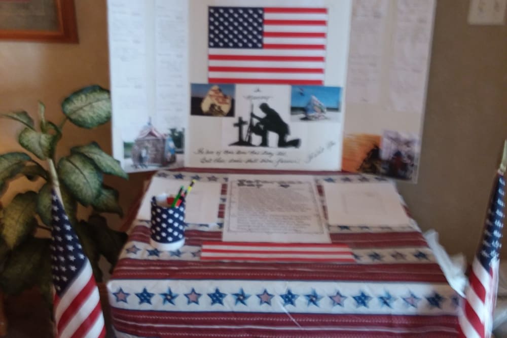 A patriotic table display featuring an American flag and memorial items.