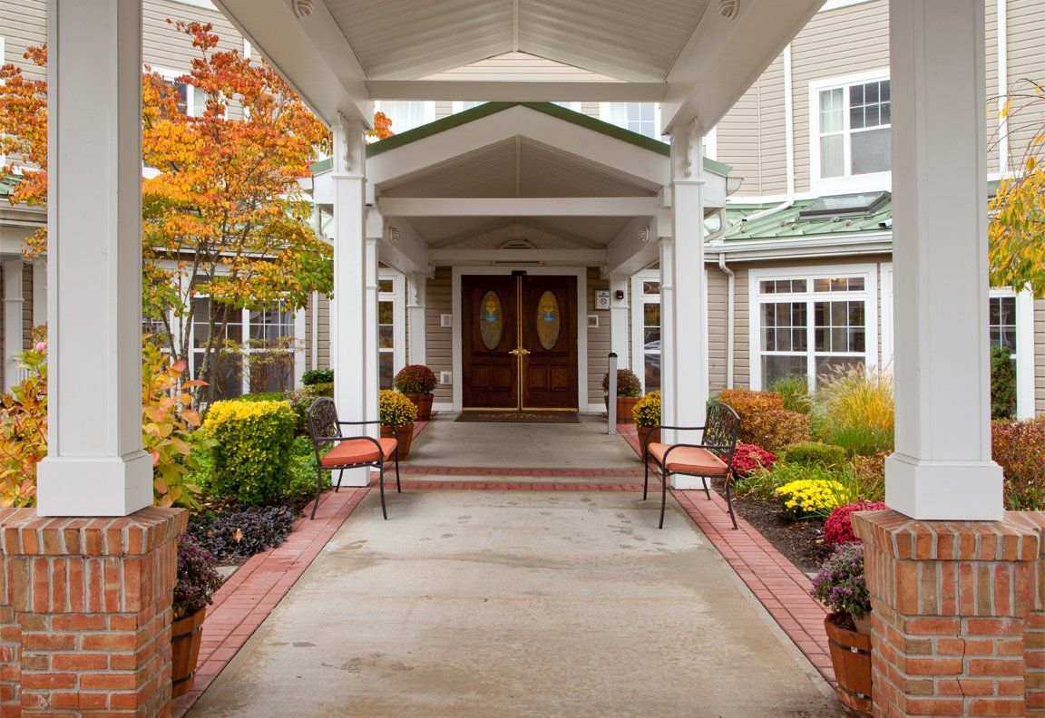 A welcoming entrance with autumnal decor and outdoor seating.