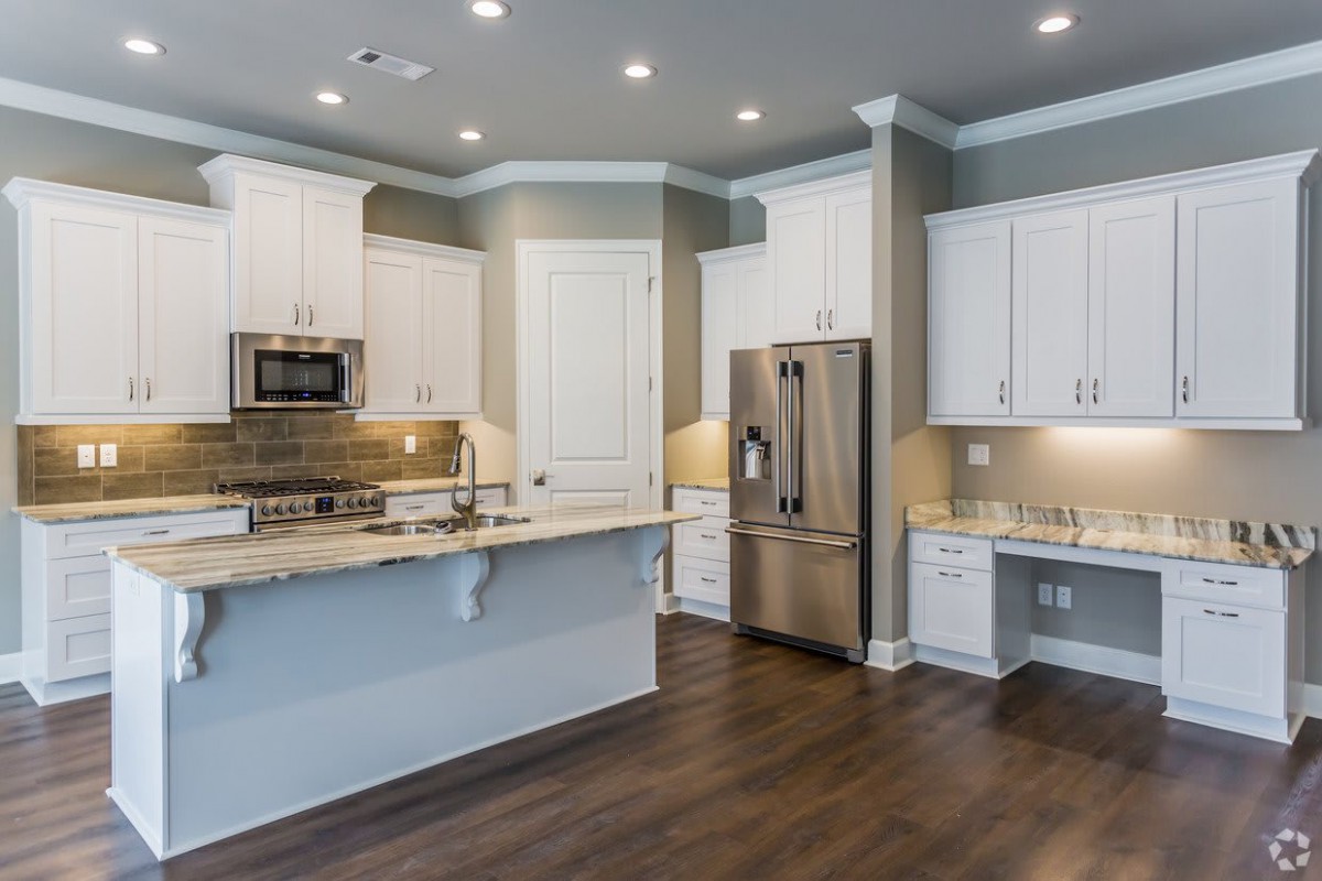 A modern kitchen featuring white cabinets and stainless steel appliances.