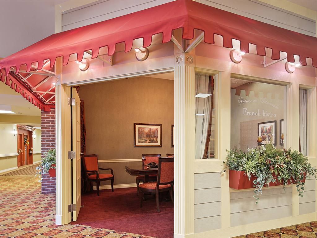 A cozy restaurant interior with a red awning and potted plants.