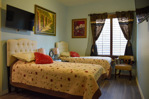 A cozy bedroom featuring two beds, decorative artwork, and warm lighting.