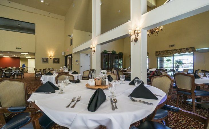 An elegantly set dining table in a spacious restaurant interior.