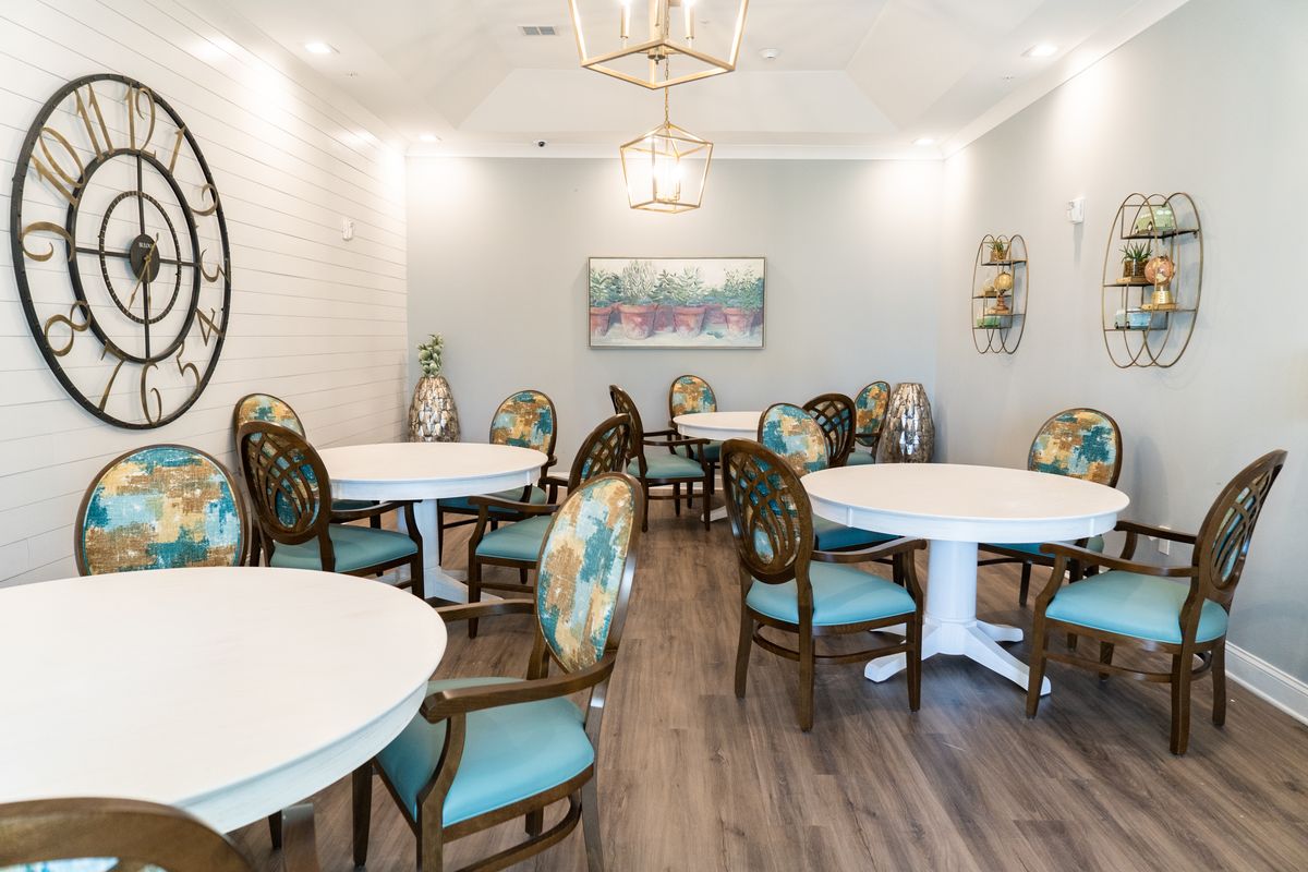 A modern dining room with elegant tables and chairs, complemented by stylish lighting fixtures and wall decorations.