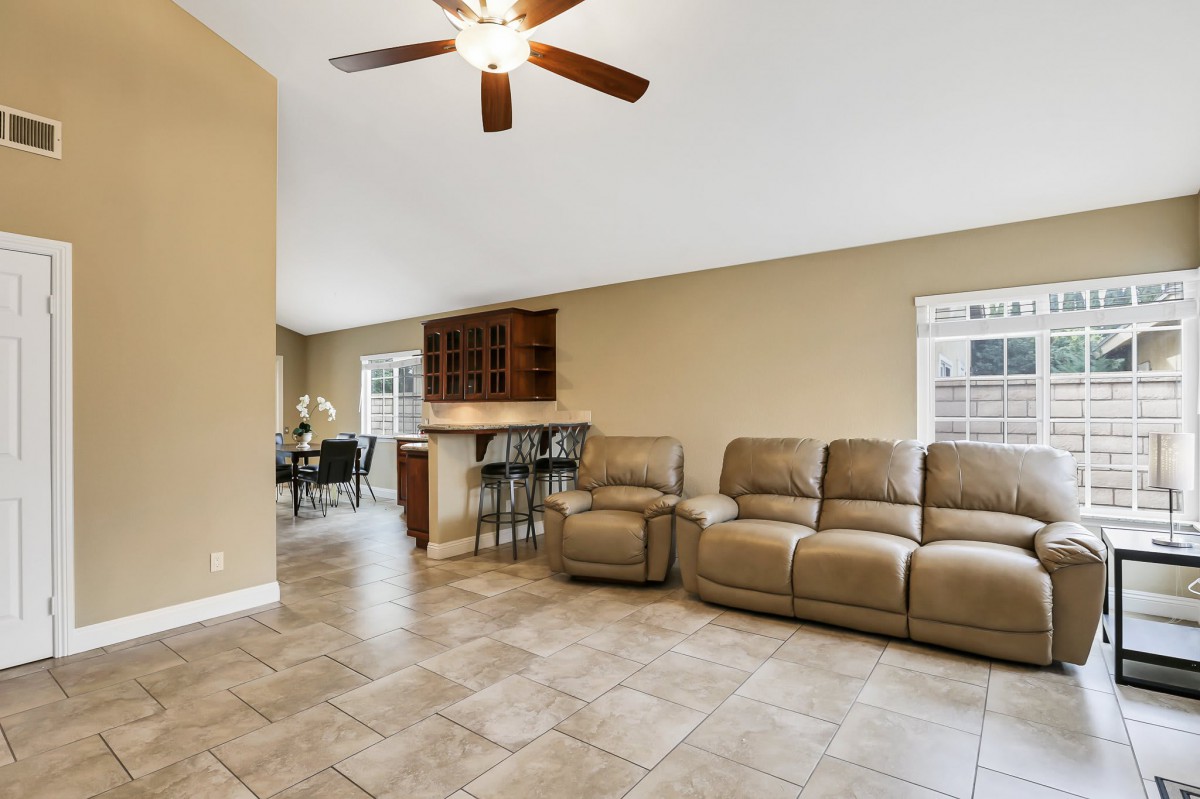 Spacious living room with a comfortable sofa and adjoining bar area.