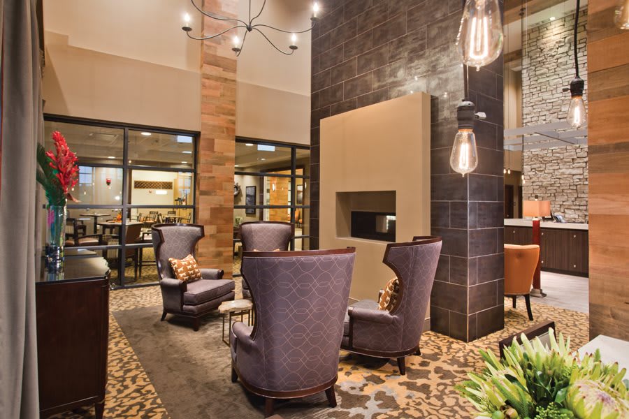 A modern hotel lobby with stylish seating and a cozy fireplace.