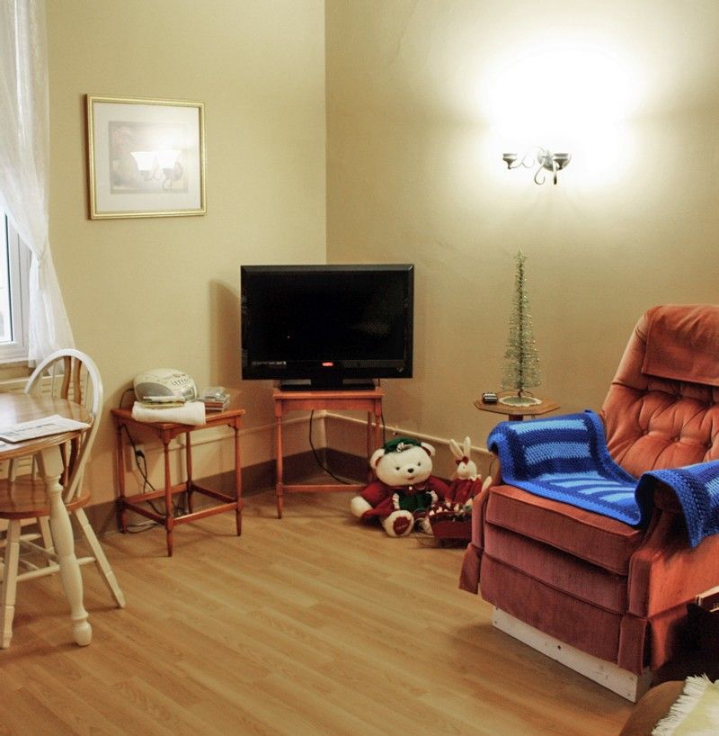 A cozy living room with a comfy chair, television, and decorative items.