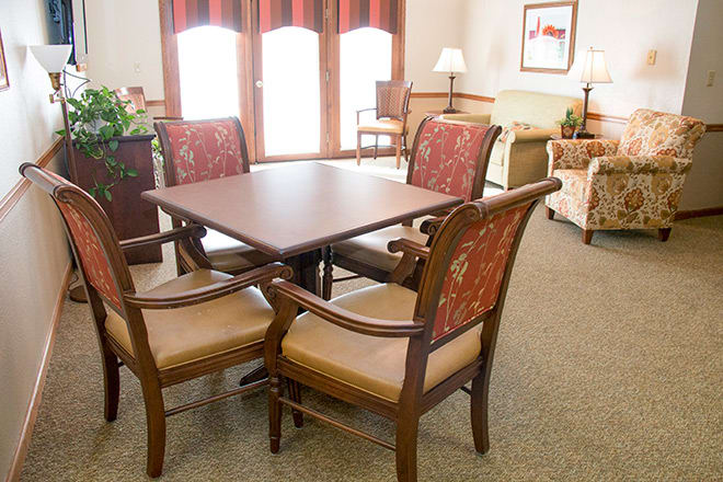 A cozy living room setting with a wooden dining table and upholstered chairs.