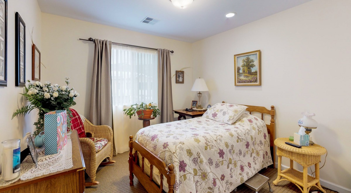 A cozy bedroom with floral bedding and a window view.