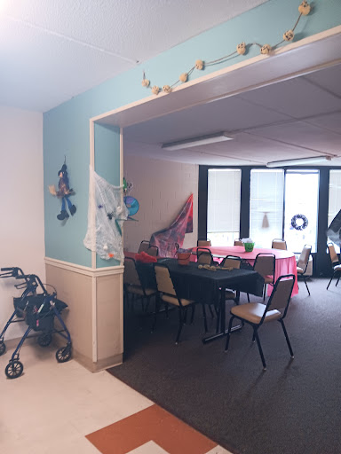 A cozy activity room with decorated tables and accessible seating.