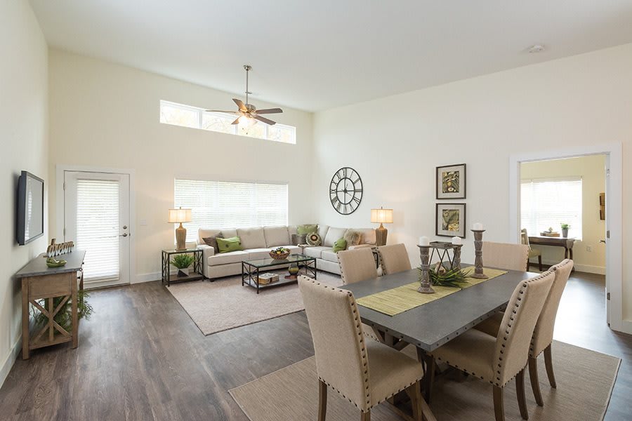 A modern living room with an open dining area, featuring stylish decor and ample natural light.