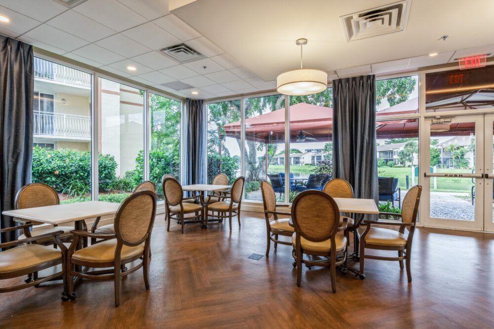 A spacious restaurant dining area with elegant furniture and large windows allowing natural light.