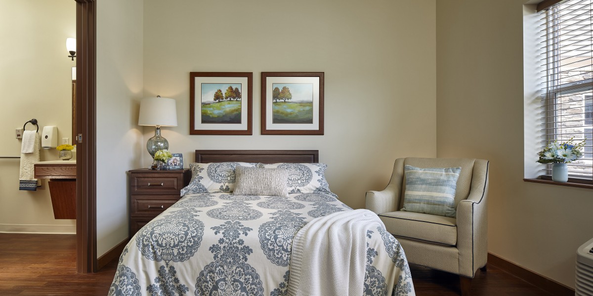 A cozy bedroom with a patterned bedspread, wall art, and elegant furniture.