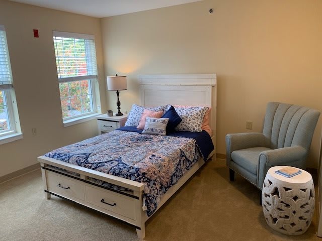 Cozy bedroom with a patterned bedspread and comfortable furnishings.