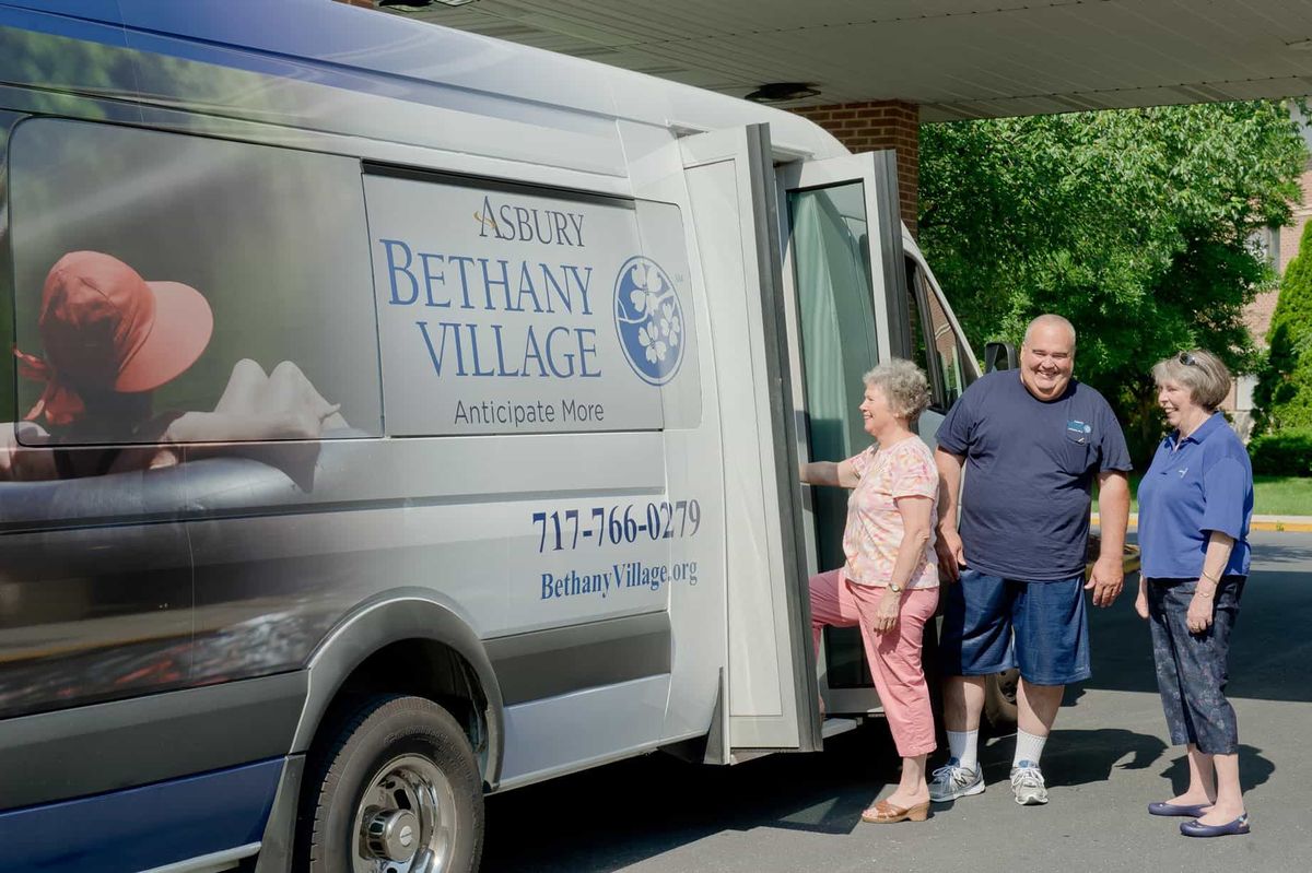 Two senior citizens prepare to board a community van outside Bethany Village.