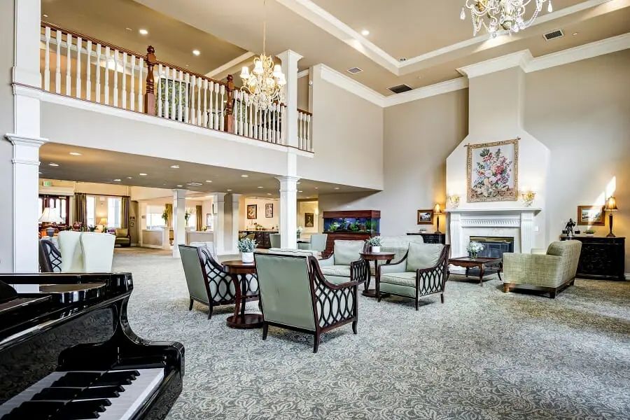 A spacious and elegant hotel lobby with luxurious furnishings, featuring a grand piano and chandelier lighting.