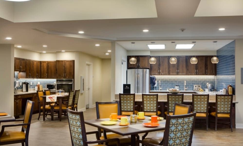 A modern dining area adjacent to an open kitchen with contemporary furniture and lighting.