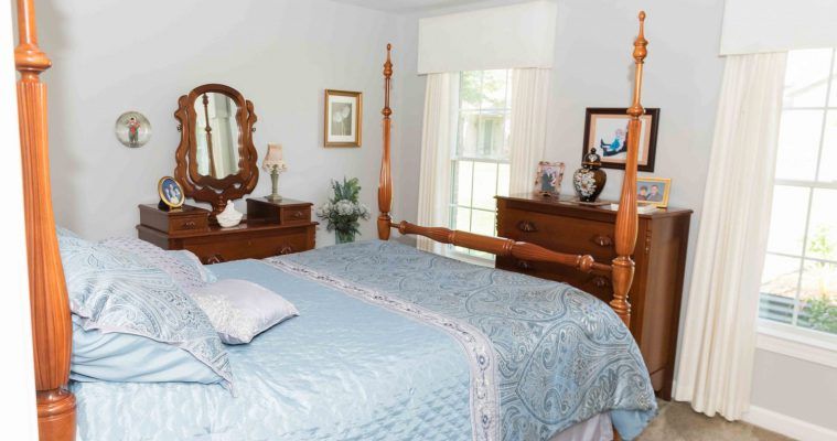 A cozy bedroom with a four-poster bed and classic wooden furniture.