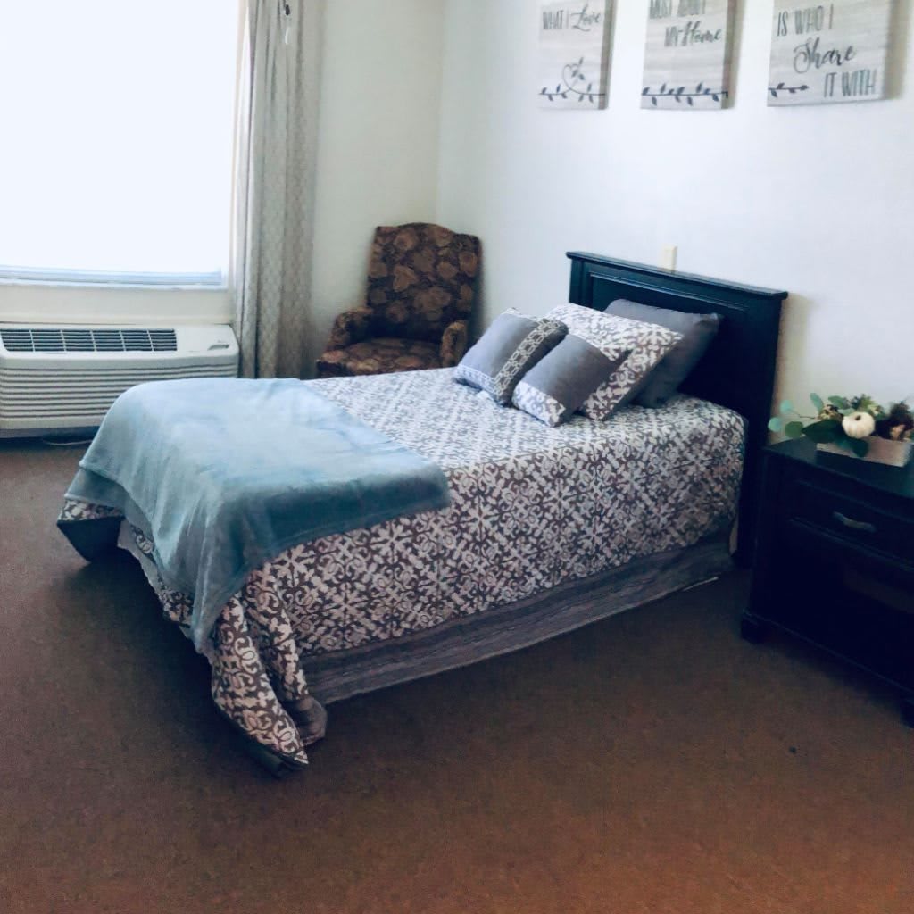 A cozy bedroom with a neatly made bed and stylish decor.