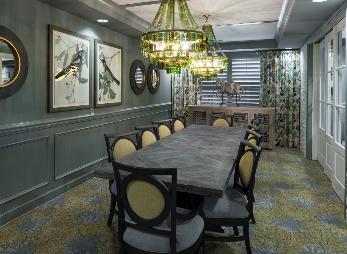 Elegant dining room with a large table, stylish chandelier, and artistic decor.