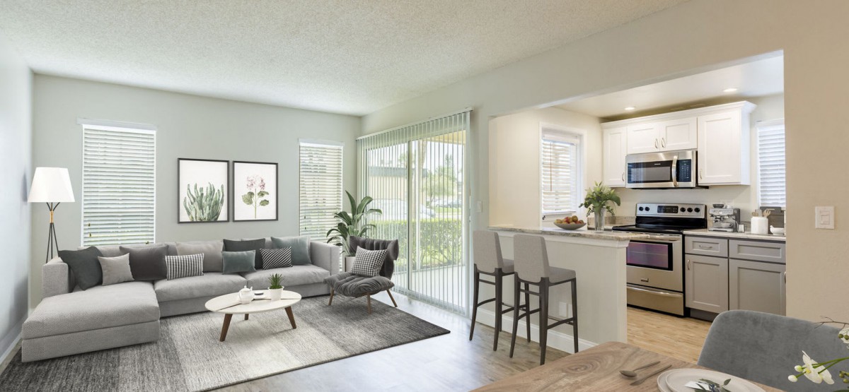 A modern living room with a cozy sofa, coffee table, and bar stools, featuring an open design with natural light.