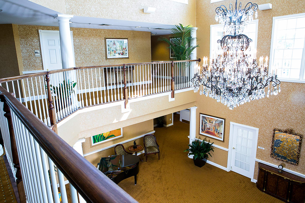 A bright and elegant lobby with a chandelier, artwork, and comfortable seating.