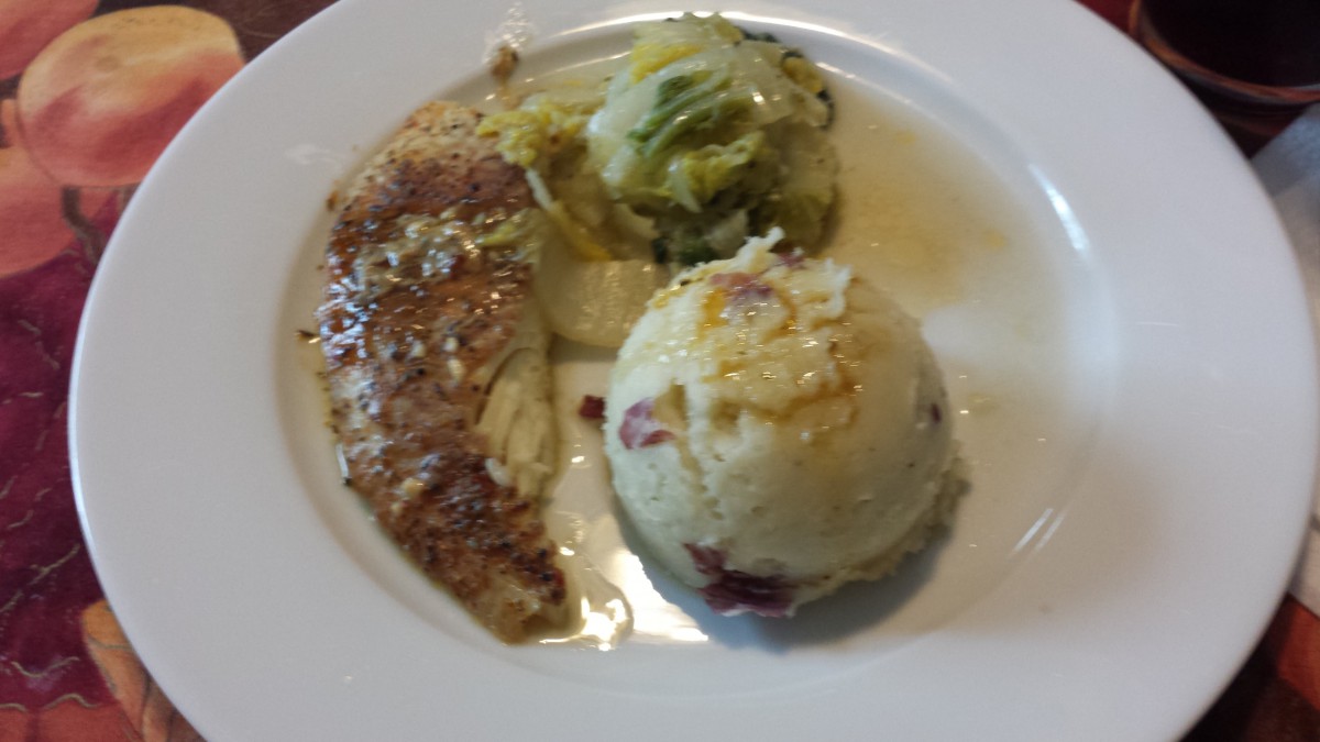 A plate featuring chicken, cabbage, and mashed potatoes.
