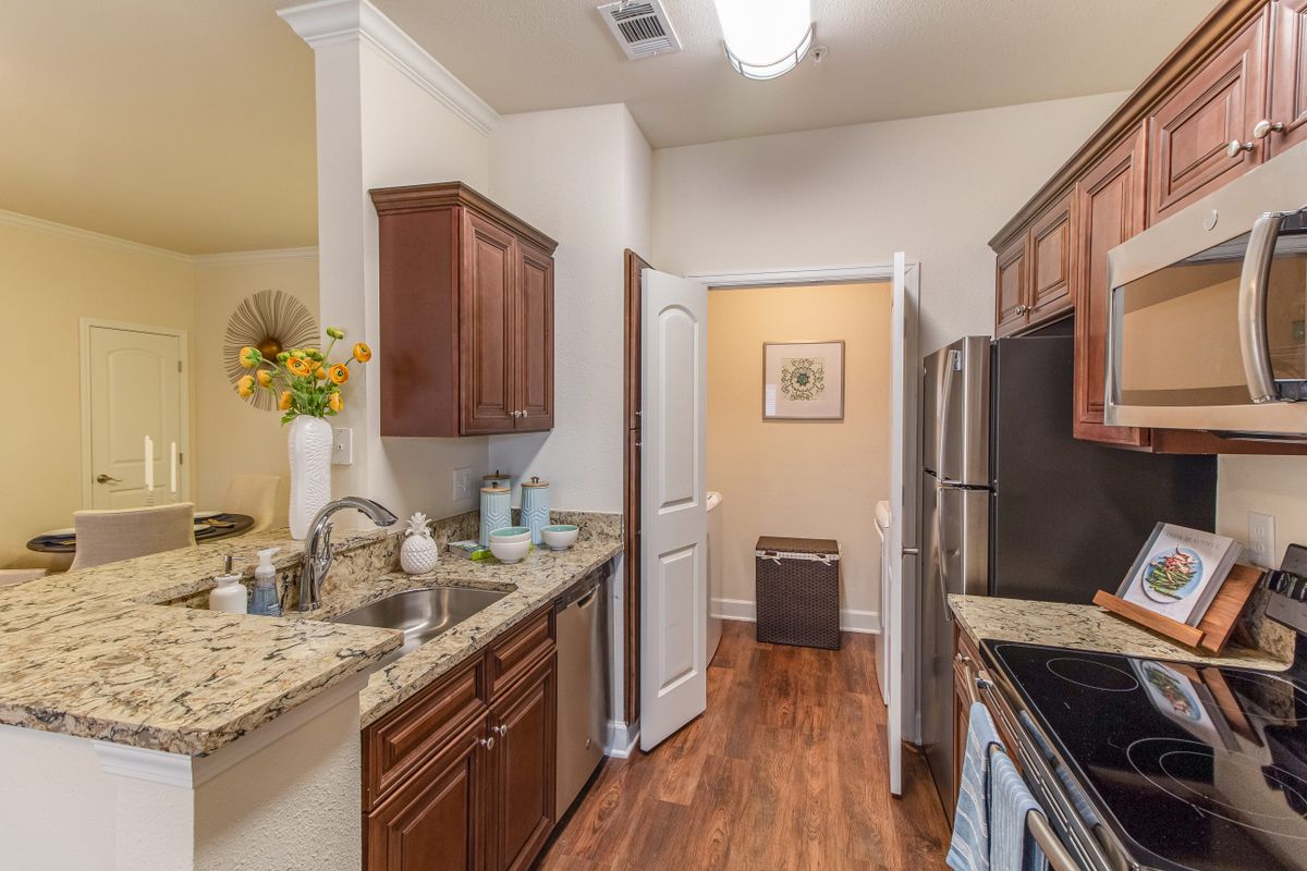 A cozy kitchen interior featuring wooden cabinets, granite countertops, and modern appliances.