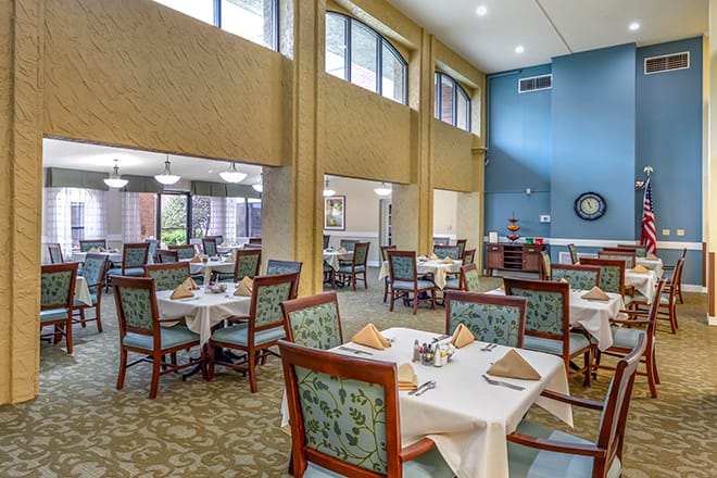 A well-lit dining area featuring neatly arranged tables and chairs.