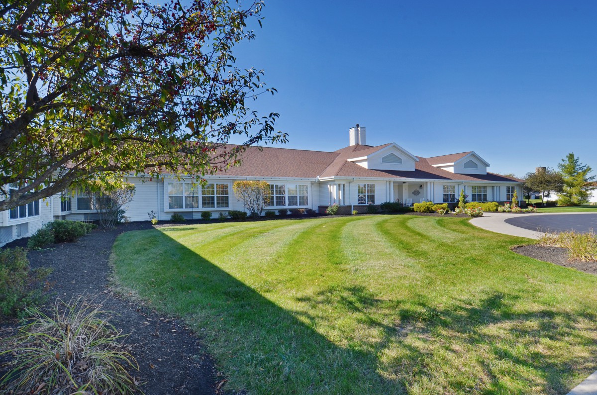A suburban home with a manicured lawn and clear blue sky.