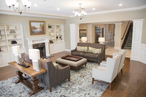 A spacious and elegantly designed living room featuring comfortable seating, a fireplace, and tasteful decor.