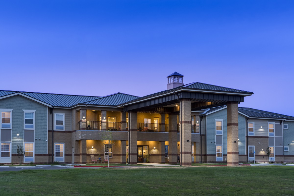 A well-lit residential building exterior at dusk.
