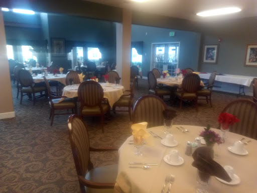 A cozy dining area set up for a meal, featuring tables with tablecloths and chairs.