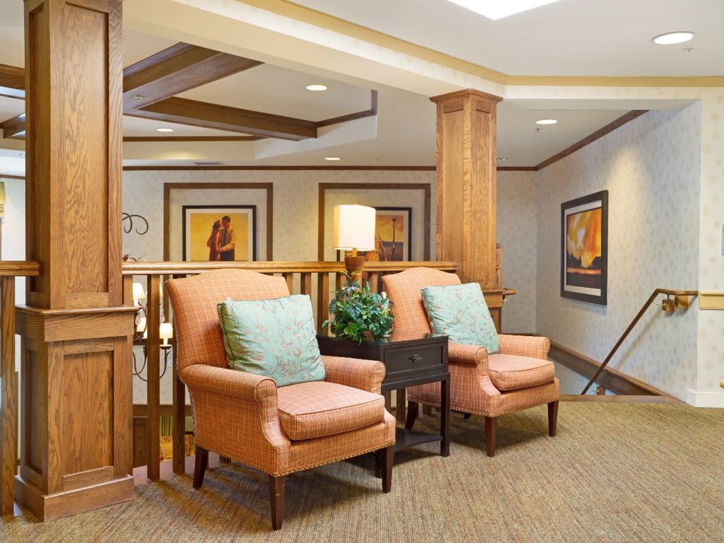 A cozy lobby seating area with plush chairs and decorative artwork.