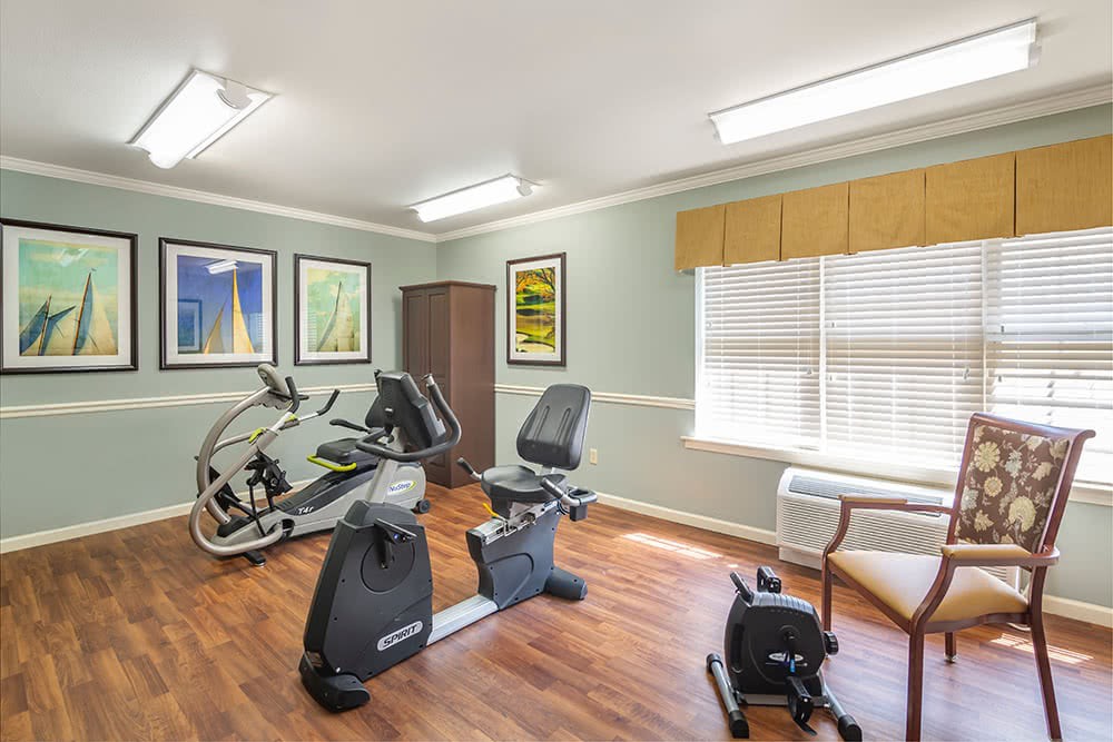 A small indoor exercise room with stationary bikes and bright lighting.