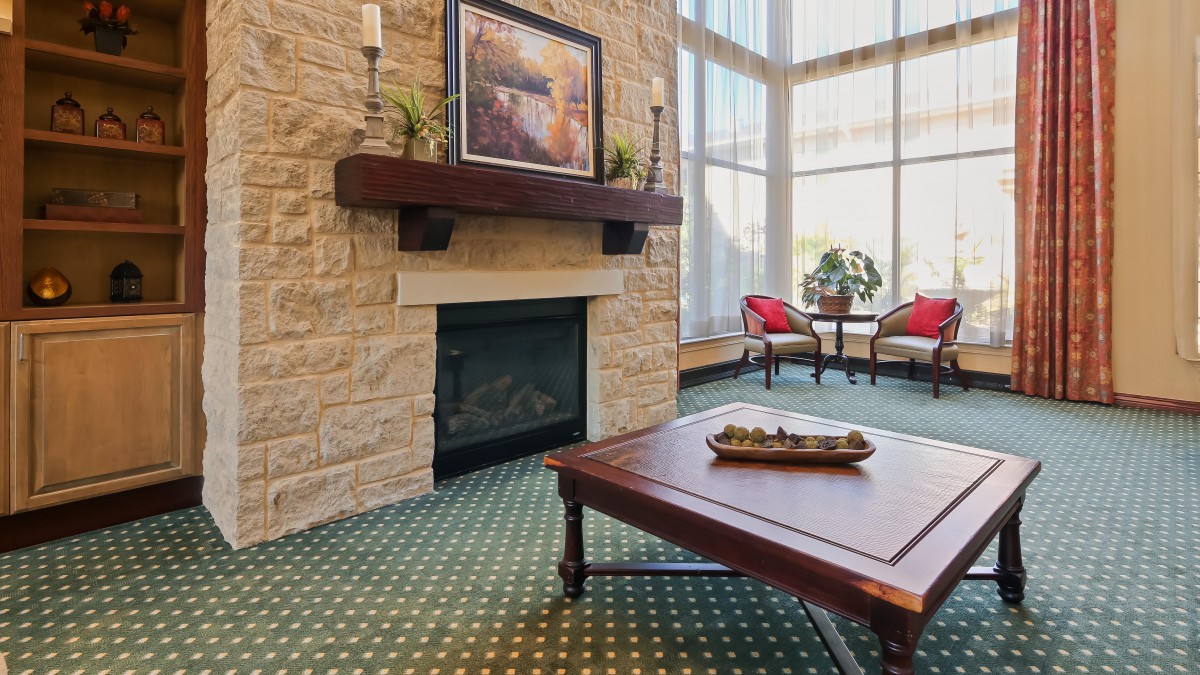 A cozy living room with a stone fireplace and elegant furniture.