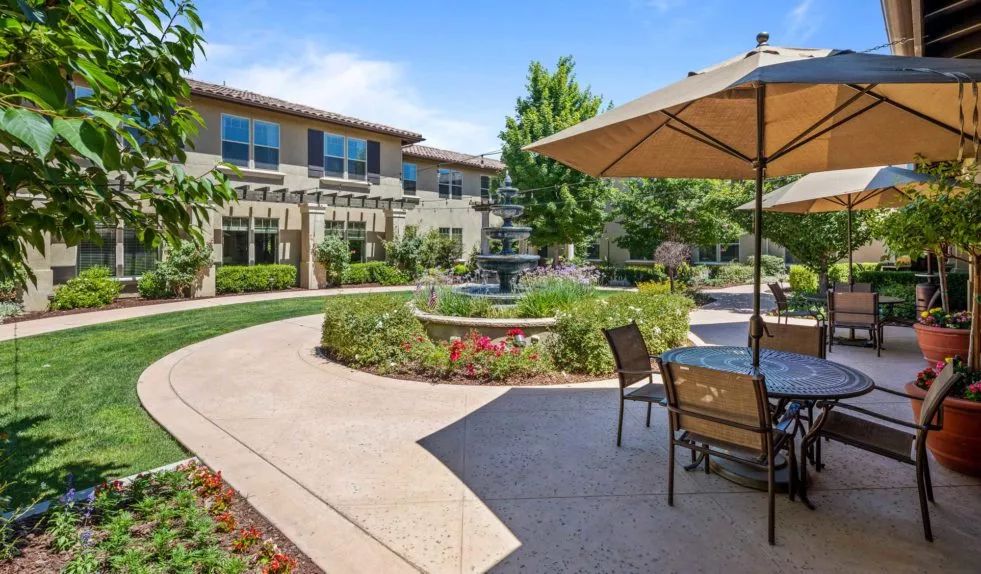 A tranquil courtyard with a central fountain, surrounded by landscaped gardens and outdoor seating.